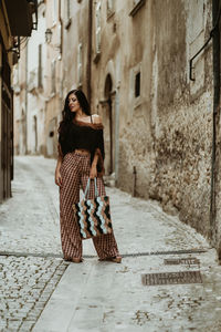 Woman standing in front of alley