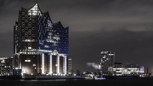 Illuminated modern building against sky