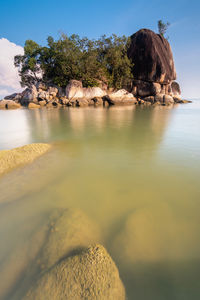 Scenic view of rocks in sea against sky