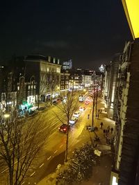 Illuminated city street against sky at night