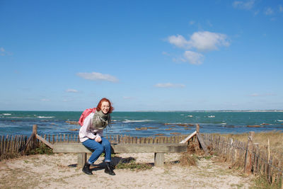 Young laughing woman sitting on beach