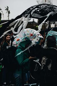 Portrait of woman with umbrella standing in rain