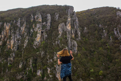 Rear view of woman standing on mountain