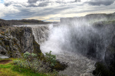 Scenic view of waterfall against sky