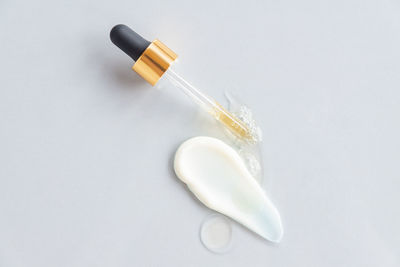 Pipette and drops and smears of cosmetics. liquid gel or a drop of serum with face cream smear. 