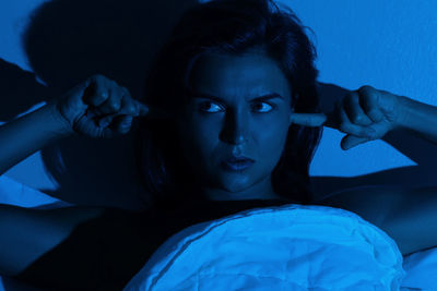 Portrait of young woman lying on bed at home