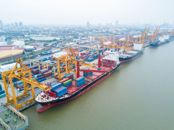 High angle view of cityscape by sea against sky