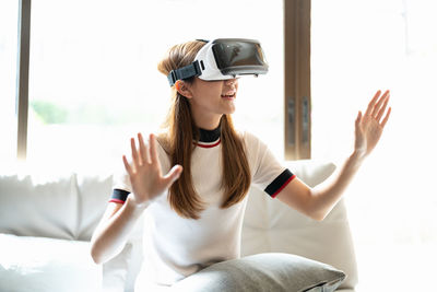 Side view of woman using mobile phone while sitting at home