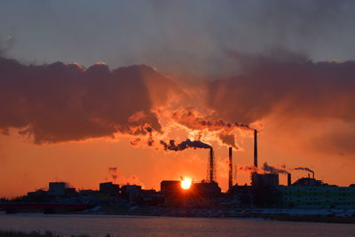 Silhouette buildings against sky during sunset