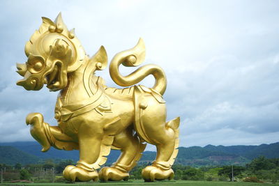 Statue of angel against cloudy sky