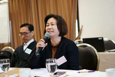 Businesswoman speaking on microphone at desk in office