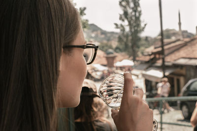 Close-up portrait of young woman drinking outdoors