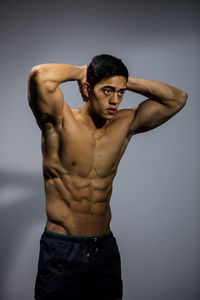 Portrait of young man against gray background