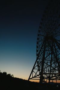 Low angle view of silhouette ferris wheel against sky at night