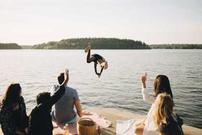 People enjoying in lake against sky