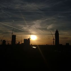 Silhouette of buildings against sky at sunset