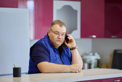 Young man using mobile phone while sitting at home