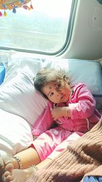 Portrait of smiling young woman sleeping on bed at home