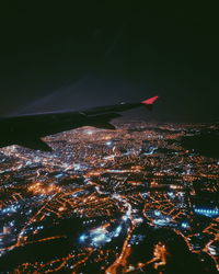 Aerial view of illuminated city against sky at night