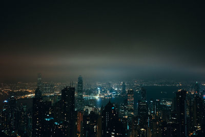 Illuminated cityscape against sky at night