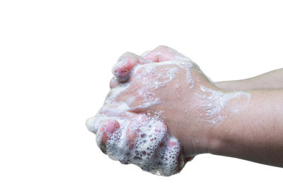 Close-up of wet hand against white background