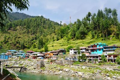 Houses by trees and mountains against sky