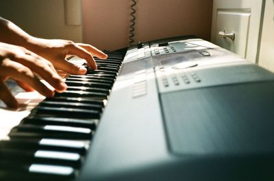 Close-up of hand playing piano