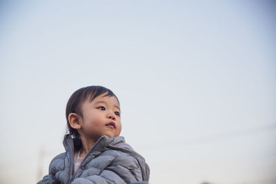 Portrait of boy looking away against sky during winter