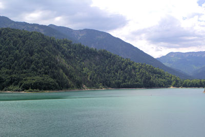 Scenic view of lake by mountains against sky