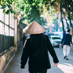 Rear view of woman with umbrella walking in city