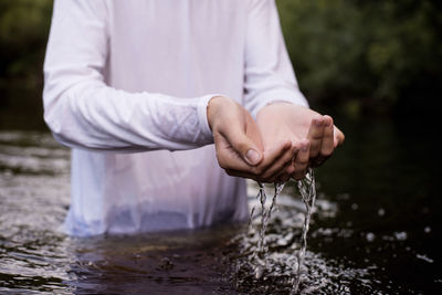 Midsection of man standing in river