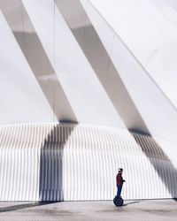 Full length side view of person walking against wall