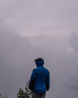 Rear view of man standing against sky