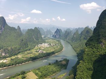 Scenic view of river amidst mountains against sky