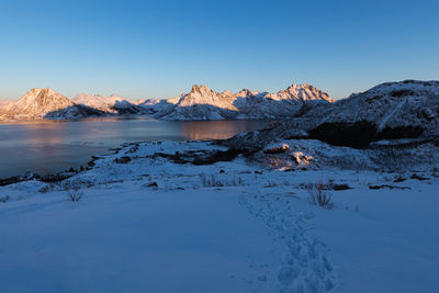 Scenic view of snowcapped mountains against clear blue sky