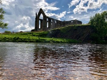 Arch bridge over river against sky