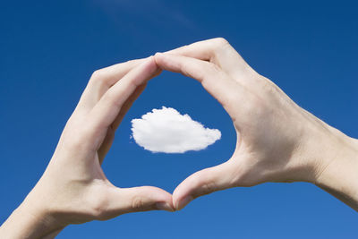 Low angle view of heart shape against blue sky