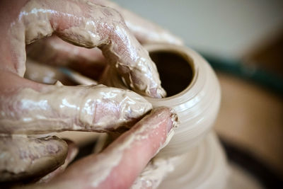 Girl sculpts in clay pot closeup. modeling clay. caucasian man making vessel daytime of white clay