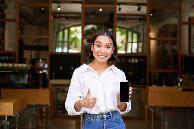 Portrait of young woman standing in cafe