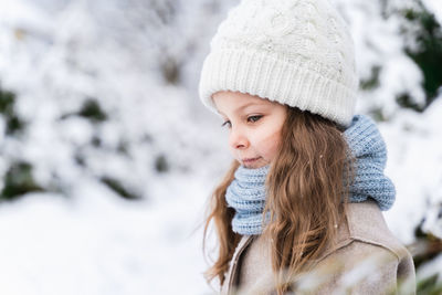 Cute girl on snow covered land during winter