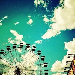 Low angle view of ferris wheel against blue sky