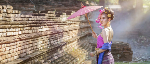 Full length of girl standing against pink wall