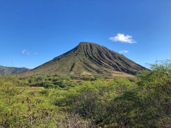 Scenic view of volcanic mountain against blue sky