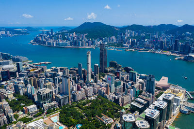 Aerial view of city by sea against sky