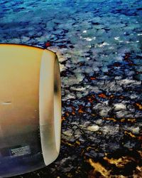 Close-up of airplane over sea against sky