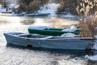 View of boats moored in lake during winter