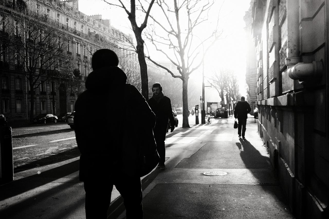 REAR VIEW OF A SILHOUETTE WOMAN WALKING ON ROAD