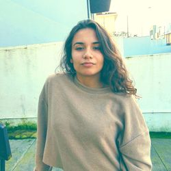 Portrait of woman standing against wall