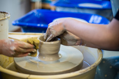 Cropped hands of people making pot