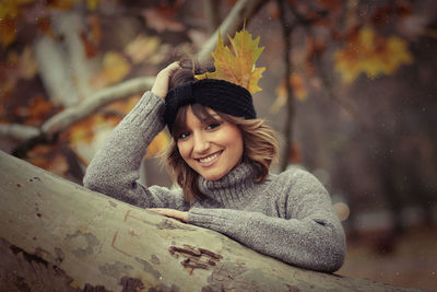 Portrait of smiling young woman by tree
